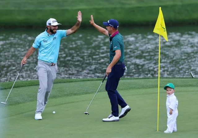 Max Homa of the U.S. celebrates with Jordan Spieth of the U.S. after Sammy, child of Jordan Spieth, drops his ball into the hole during the par 3 tournament at the Augusta National Golf Club in Augusta, Georgia on April 5, 2023. (Photo by Mike Blake/Reuters)