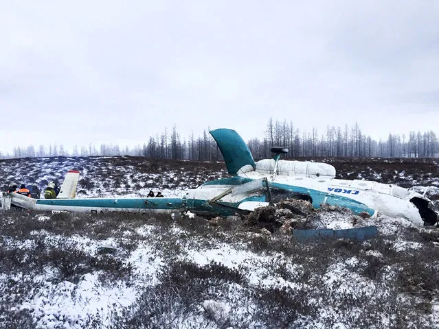 In this handout photo, made available by Russian Emergency Situations Ministry, Saturday, October 22, 2016, a Mi-8 helicopter lies on the ground after it crashed about 45 kilometers (28 miles) northeast of Staryi Urengoi in Hassana, Russia. Russia's aviation agency says 19 people have died after a helicopter carrying oil workers crashed. (Photo by Russian Ministry for Emergency Situations photo via AP Photo)