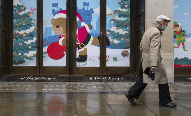 A man walks past closed shops on Regent Street, in London on Monday December 21, 2020. Millions of people in England have learned they must cancel their Christmas get-togethers and holiday shopping trips. British Prime Minister Boris Johnson said Saturday that holiday gatherings can’t go ahead and non-essential shops must close in London and much of southern England. (Photo by Dominic Lipinski/PA Wire via AP Photo)