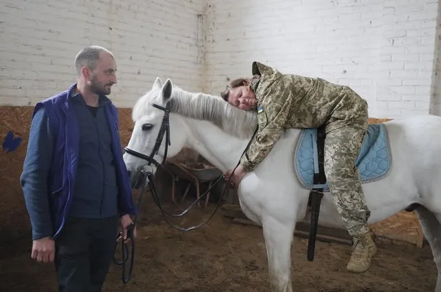 Ukrainian service personnel participate in hippotherapy at the Spirit rehabilitation center on the racecourse in Kyiv, Ukraine, 12 April 2023, amid Russia's invasion. More than 300 Ukrainian servicemen suffering from post-traumatic stress disorder have been treated at the center for mental healing since November 2022 where mental recovery is encouraged through communication with animals. Russian troops entered Ukraine on 24 February resulting in fighting and destruction in the country and triggering a series of severe economic sanctions on Russia by Western countries. (Photo by Sergey Dolzhenko/EPA)
