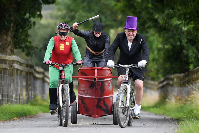 A dynamic trio compete in the World Mountain Bike Chariot Racing Championship, fancy dress encouraged, over two laps of an on-and-off road course of 1,200 yards (1km) in Llanwrtyd Wells, Wales, UK on August 9, 2025. (Photo by Huw Evans)