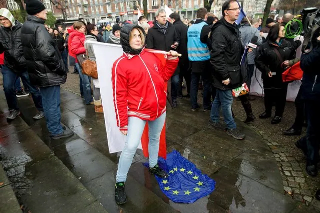 A woman stands on an EU flag during a march organised by far-right and nationalists organisations under the title "No! For migrants" in Gdansk, northern Poland, November 22, 2015. (Photo by Rafal Malko/Reuters/Agencja Gazeta)