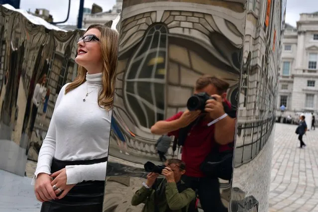 Photographers are reflected as they take pictures of Celine Xhixha as she poses next to an installation entitled “Bliss” created by her step-father, Helidon Xhixha, who is representing Albania at the London Design Biennale at Somerset House on September 6, 2016 in London, England. (Photo by Carl Court/Getty Images)
