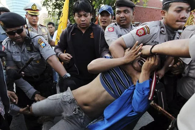 Police detain a student protester after he and fellow protesters attempted to enter the governor's office to oppose hikes in fuel prices in Surabaya, East Java province June 21, 2013. Indonesia will carry out a big increase in fuel prices on Saturday, settling months of agonising over the politically divisive issue that was damaging confidence in Southeast Asia's biggest economy and sapping the state's finances. (Photo by Rayhan Alifian/Reuters)