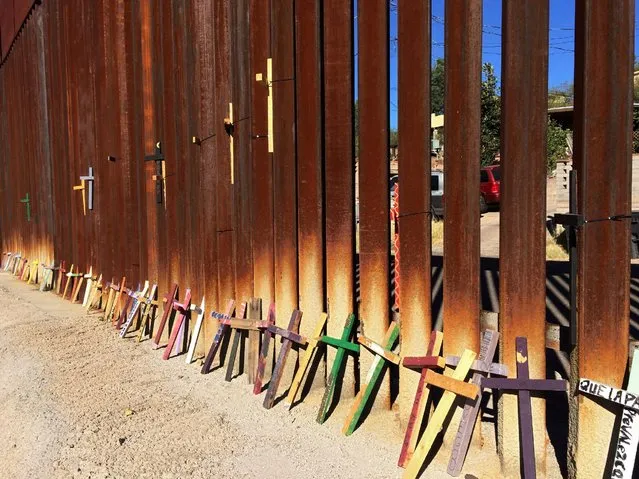 Wooden crosses, in memory of migrants who died crossing to the U.S., lean on the border fence between Mexico and the U.S. in Nogales, in Sonora state, Mexico, November 10, 2016. Picture taken November 10, 2016. Picture taken from the Mexico side of the U.S.-Mexico border. (Photo by David Alire Garcia/Reuters)