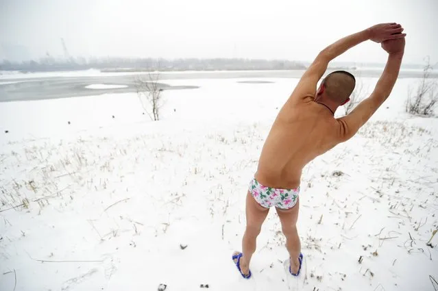 Winter swimmer Li Wenyan, 43, stretches before getting in a partially frozen river in Taiyuan, Shanxi province, January 24, 2015. (Photo by Reuters/Stringer)