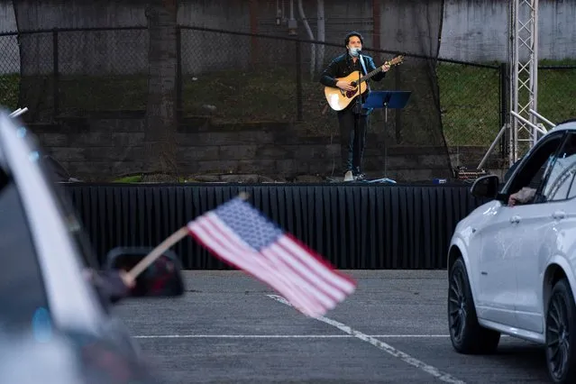 A musician performs during a drive-in coronavirus disease (COVID-19) Victims and Survivors Memorial Day vigil in a parking lot of the Tacoma Dome in Tacoma, Washington, U.S. March 1, 2021. (Photo by David Ryder/Reuters)
