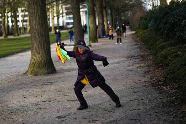 In this Tuesday, January 26, 2021 file photo, a woman wields a sword as she practices Tai Chi at the Cinquantenaire park in Brussels. In a pandemic time rife with restrictions, demands to respect social distancing have become quasi impossible to respect in public parks. One family in town though, has a lush garden all its own and ever more voices are being raised that the Royal Family of King Philippe should loosen up and open up at least part of their Park of Laeken to the public. (Photo by Francisco Seco/AP Photo/File)