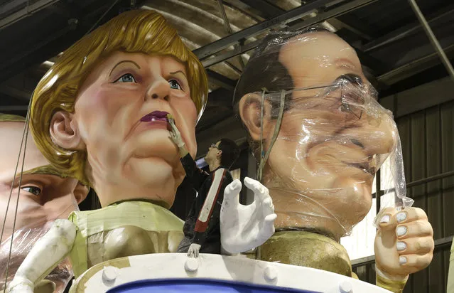 A man puts the final touches on a giant figure showing German Chancellor Angela Merkel , next to France's President Francois Hollande during preparations for the 131st Nice carnival parade , Thursday, February 5, 2015 in Nice, southeastern France. The Carnival, running from Feb. 13 until March 1, 2015, celebrates the “King of Music”. (Photo by Lionel Cironneau/AP Photo)