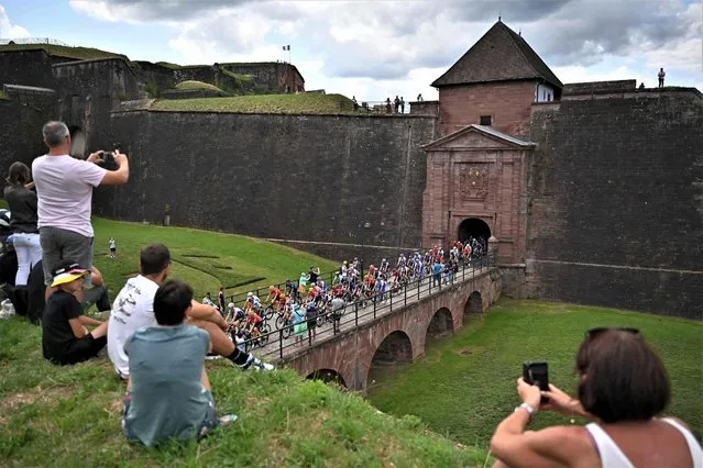 The pack of riders cycles through the “Citadelle de Belfort” at the start of the 20th stage of the 110th edition of the Tour de France cycling race 133 km between Belfort and Le Markstein Fellering, in Eastern France, on July 22, 2023. (Photo by Marco Bertorello/AFP Photo)