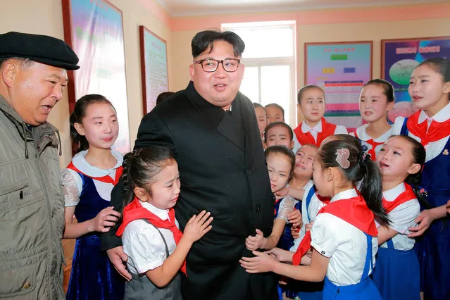 North Korean leader Kim Jong Un is hugged by children during his visit to Samjiyon County in this undated photo released by North Korea's Korean Central News Agency (KCNA) in Pyongyang November 28, 2016. (Photo by Reuters/KCNA)