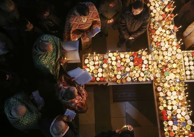 Orthodox priests gather around candles stuck to jars with honey, during a religious mass in the church of the Presentation of the Blessed Virgin in the city of Blagoevgrad February 10, 2015. (Photo by Stoyan Nenov/Reuters)