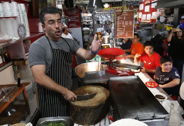 Tenor Dante Alcala performs in a taco stand of the Argentina market in Mexico City, Saturday, August 25, 2018. The country's Fine Arts Institute is bringing classically trained singers to brighten the days of shoppers and workers of the markets, with renditions from world-famous operas. (Photo by Marco Ugarte/AP Photo)