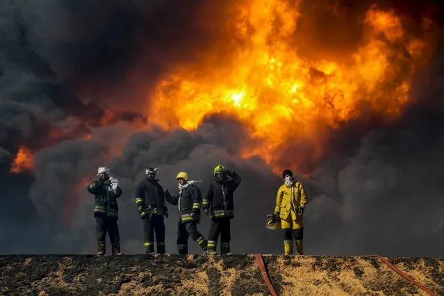 Firefighters stand will trying to put out a fire in an oil tank in the port of Es Sider, in Ras Lanuf, Libya, January 6, 2016. Firefighters have extinguished two fires at oil storage tanks at Libya's Ras Lanuf terminal, but blazes continue at five tanks in the nearby port of Es Sider after attacks this week by Islamic State militants, a Petroleum Facilities Guards (PFG) spokesman said on Thursday. (Photo by Reuters/Stringer)