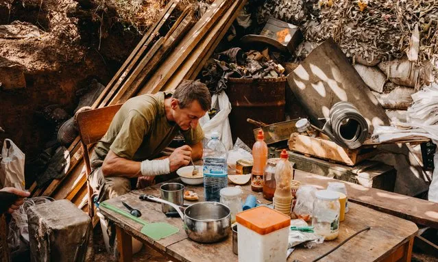 Ukrainian soldier, from the 24th separate mechanized brigade, named after King Danylo, eats his dinner in the front line positions near New York, Donbass, Ukraine on August 08, 2023. New York had nearly had ten thousand residents before the war, and despite the constant shelling of Russian forces, there are still approximately a thousand residents here. Although the frontline here is stable, Russian forces are positioned about 700-800 meters away, so the city is under constant fire. (Photo by Wojciech Grzedzinski/Anadolu Agency via Getty Images)