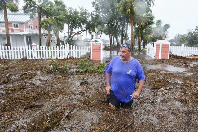 Daniel Dickert wades through water in front of his home where the Steinhatchee River overflowed on Wednesday, August 30, 2023, in Steinhatchee, Fla., after the arrival of Hurricane Idalia. (Photo by Douglas R. Clifford/Tampa Bay Times via AP Photo)