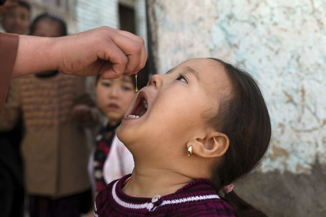Shabana Maani, gives a polio vaccination to a child in the old part of Kabul, Afghanistan, Monday, March 29, 2021. Afghanistan is inoculating millions of children against polio after pandemic lockdowns stalled the effort to eradicate the crippling disease. But the recent killing of three vaccinators points to the dangers facing the campaign. (Photo by Rahmat Gul/AP Photo)
