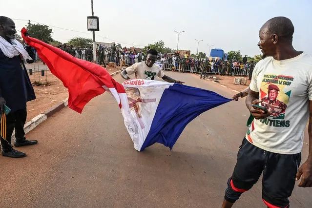 Supporters of Niger's National Council of Safeguard of the Homeland (CNSP) trample on a French national flag during a protest outside Niger and French airbase in Niamey on September 1, 2023 to demand the departure of the French army from Niger. (Photo by AFP Photo/Stringer)