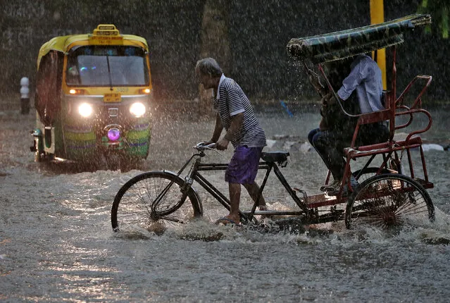 A man pedals his cycle rickshaw during monsoon rains in New Delhi, August 31, 2016. (Photo by Cathal McNaughton/Reuters)