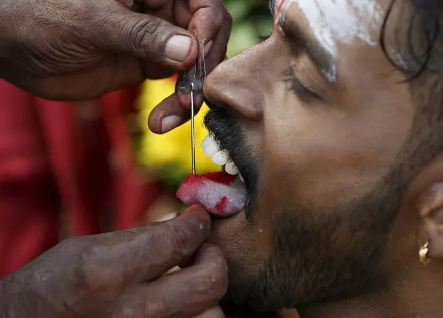 A Hindu devotee reacts as his tongue is pierced during Thaipusam at Batu Caves in Kuala Lumpur, Malaysia, January 23, 2016. (Photo by Olivia Harris/Reuters)