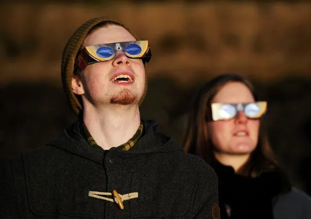 People wearing solar viewing glasses observe a partial solar elcipse in Reykjavik March 20, 2015. (Photo by Sigtryggur Ari/Reuters)
