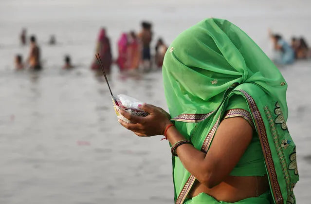 A Hindu devotee performs morning rituals along the banks of the Ganges River on “Ashtami”, or the eighth day during the nine-day Hindu festival of Navratri, in Allahabad, India, Friday, March 27, 2015. Navratri honors the Hindu goddess Shakti, or divine mother. (Photo by Rajesh Kumar Singh/AP Photo)
