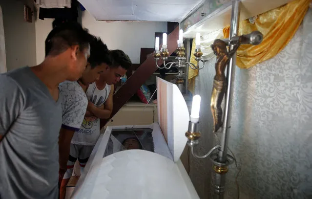 Friends look at the body of Kenneth Lim, 20, who was shot dead by suspected vigilantes at a house storing illegal narcotics, police said on Thursday, in Caloocan city, Metro Manila, in the Philippines December 29, 2016. (Photo by Erik De Castro/Reuters)