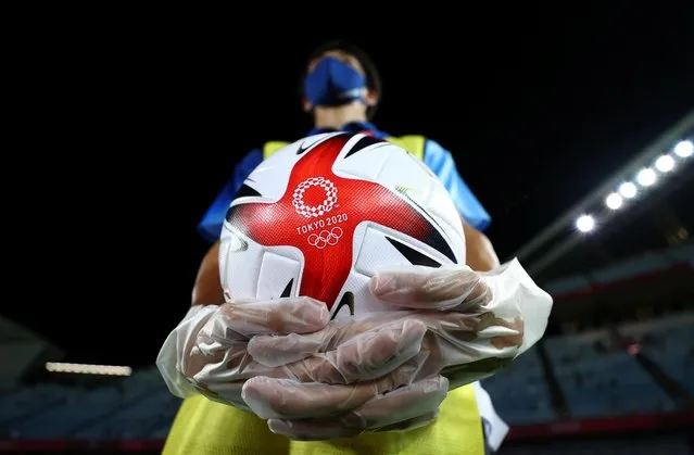 Member of staff wearing Personal Protective Equipment (PPE) holds a ball before the match Netherlands v Brazil in Miyagi Stadium, Miyagi, Japan on July 24, 2021. (Photo by Amr Abdallah Dalsh/Reuters)