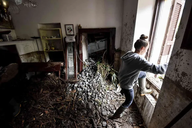 A woman clears her flooded home following floods in Laglio, Como Lake, northern Italy, Wednesday July, 28, 2021. Towns around Italy’s Lake Como have been hit by mudslides and floods in yet another example of extreme weather phenomena that an agricultural lobby says have intensified in recent years. Italian firefighters carried out more than 60 rescues Tuesday after storms wreaked havoc around the picturesque lake ringed by mountains in northern Italy. (Photo by Claudio Furlan/LaPresse via AP Photo)