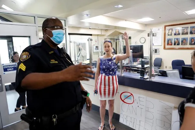 A parent and a member of the “Community Patriots” confronts a police officer while protesting against wearing masks in schools before the special called school board workshop at the Pinellas County Schools Administration Building in Largo, Florida, U.S., August 9, 2021. (Photo by Octavio Jones/Reuters)