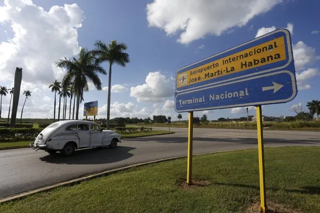 A vintage car drives next to a street sign indicating directions at the Jose Marti International Airport, in Havana, December 17, 2015. (Photo by Reuters/Stringer)