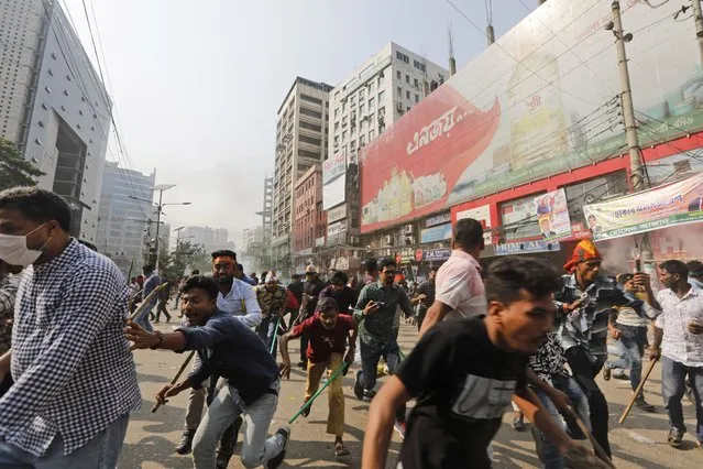 Activists of the Bangladesh Nationalist Party run after clashing with police during a protest in Dhaka, Bangladesh, Saturday, October 28, 2023. Police in Bangladesh's capital fired tear gas to disperse supporters of the main opposition party who threw stones at security officials during a rally demanding the resignation of Prime Minister Sheikh Hasina and the transfer of power to a non-partisan caretaker government to oversee general elections next year. (Photo by Mahmud Hossain Opu/AP Photo)