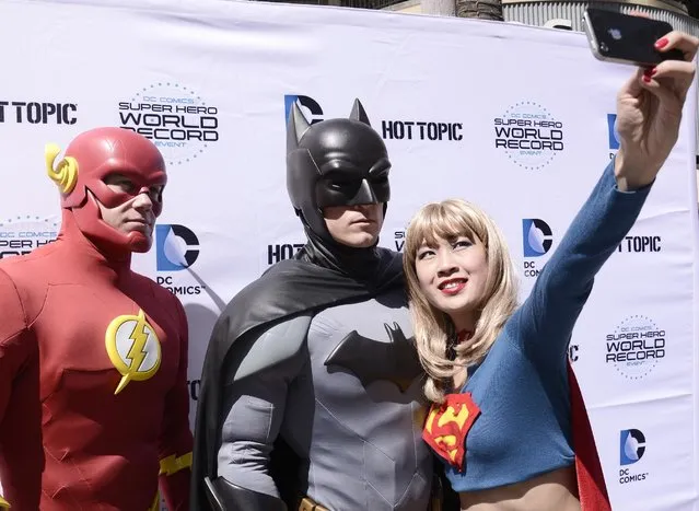 Fans pose for a selfie dressed as DC Comics Super Heroes at the DC Comics Super Hero World Record Event to set a Guinness World Record at the Hollywood & Highland Center on Saturday, April 18, 2015, in Los Angeles. (Photo by Dan Steinberg/Invision for Warner Bros. Consumer Products/AP Images)
