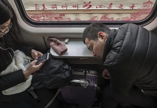 A Chinese traveler sleeps on a train between Beijing and Shijiazhuang on January 25, 2017 in Hebei province, northern China. (Photo by Kevin Frayer/Getty Images)
