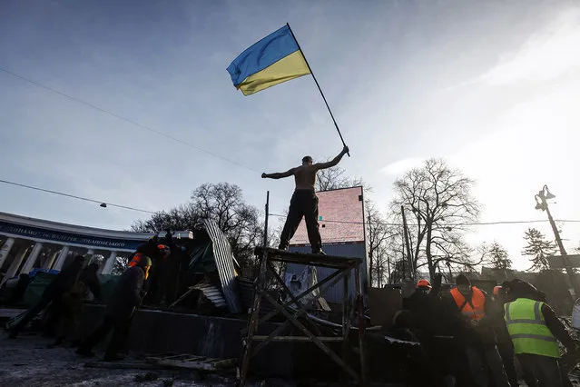 A pro-European integration protester stands with a national flag on a barricade during a rally in Kiev January 20, 2014. (Photo by Vasily Fedosenko/Reuters)