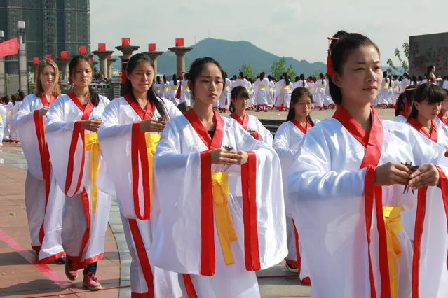 Nearly one thousand girls between 14 and 24 years old wearing traditional clothing receive coming-of-age ceremony on April 21, 2015 in Huaihua, Hunan province of China. The traditional Shangsi festival, also known as March 3 Festival, fell on the third day of the third month each year, according to Chinese lunar calendar and It was a festival to ward off misfortunes and pray for blessings in ancient China. (Photo by ChinaFotoPress/Getty Images)