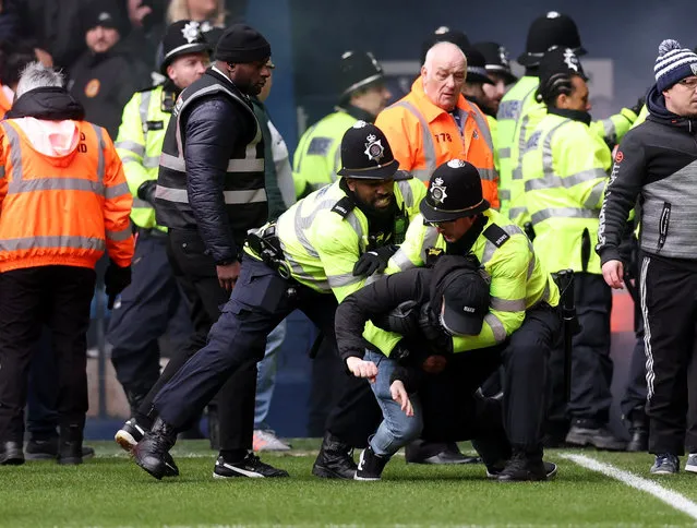 Police detain a fan as play is stopped due to crowd trouble during the Emirates FA Cup Fourth Round match between West Bromwich Albion and Wolverhampton Wanderers at The Hawthorns on January 28, 2024 in West Bromwich, England. (Photo by David Klein/Reuters)
