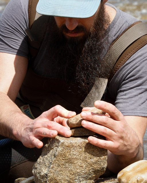 Tim Anderson, rock balancing “pro” from Pennsylvania, carefully works to balance his stack on a dry spot in the Llano river Saturday March 12, 2016. He was an honored guest of the festival and enjoyed visiting Texas so he came for another year. The river was higher this year because of the rains so the balancers could not get to the better rock that were available last year. (Photo by Nell Carroll/American-Statesman)
