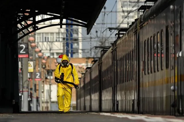 A serviceman of Russia's Emergencies Ministry wearing protective gear disinfects Moscow's Savelovsky railway station on October 26, 2021, amid the ongoing coronavirus Covid-19 disease pandemic. Russia has officially recorded 36 446 coronavirus cases and 1 106 death on October 26. Moscow will shut non-essential services between October 28 and November 7. Russian President Vladimir Putin ordered a nationwide paid week off starting October 30 to curb fast spreading infections. (Photo by Kirill Kudryavtsev/AFP Photo)