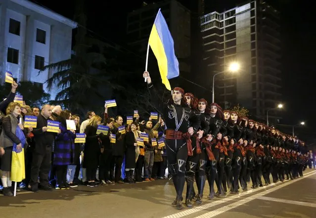 Dancers perform with Ukrainian flag during a rally demanding the liberation of Ukrainian army pilot Nadezhda Savchenko by Russia in Tbilisi, Georgia, March 21, 2016. (Photo by David Mdzinarishvili/Reuters)