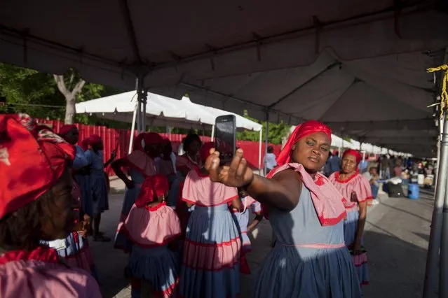 A woman dressed in the traditional dress of a Haitian agricultural worker poses for a selfie before the start of a May Day parade, in Port-au-Prince, Haiti, Friday, May 1, 2015. (Photo by Dieu Nalio Chery/AP Photo)