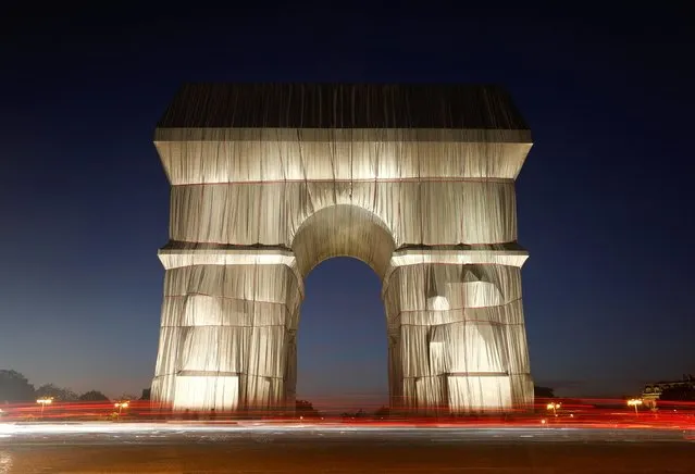 A long time exposure shows the fully wrapped Arc de Triomphe monument, as part of an installation entitled 'L'Arc de Triomphe, Wrapped' conceived by the late artists Christo and Jeanne-Claude, on the Champs Elysee avenue, in Paris, France, September 23, 2021. (Photo by Christian Hartmann/Reuters)