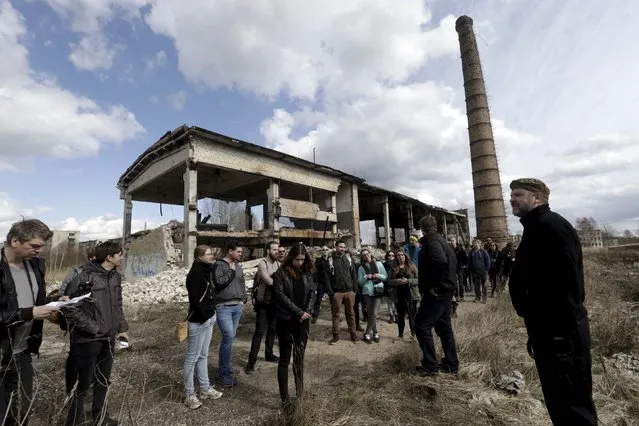 People listen to a guide (R) during the tour in the ghost town of a former Soviet military radar station near Skrunda, Latvia, April 9, 2016. (Photo by Ints Kalnins/Reuters)