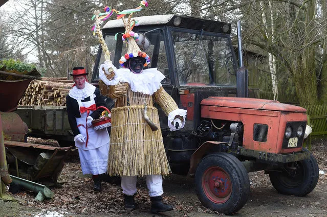 Men dressed in traditional folklore costumes parade through the village of Vortova near the East Bohemian city of Pardubice during the Czech traditional Masopust carnival on February 25, 2017. The festival marks the beginning of Lent, and is the equivalent of Mardi Gras in Latin America or Carnival in Catholic parts of Europe. (Photo by Michal Cizek/AFP Photo)