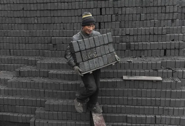 A labourer carries honeycomb briquettes at a coal processing factory in Shenyang, Liaoning province in this December 2, 2009 file photo. A surprise spike in iron ore prices in 2016 is shaking out fresh supplies of the steelmaking raw material, but some miners say it is too soon to aggressively restart production shuttered by a years-long price rout. (Photo by Sheng Li/Reuters)