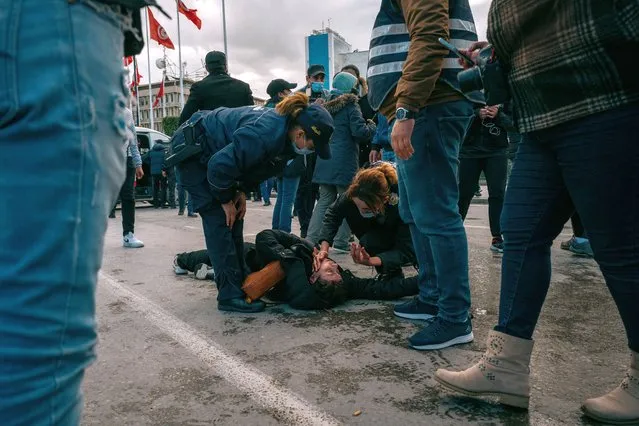 A Tunisian man lies on the ground as protesters clash with police during protests against President Kais Saied, on the 11th anniversary of the Tunisian revolution in the capital Tunis on January 14, 2022. Tunisian police used teargas today against hundreds of demonstrators who had defied a ban on gatherings to protest against President Kais Saied's July power grab. As the country marks 11 years since the fall of late dictator Zine El Abidine Ben Ali, hundreds of Saied's opponents staged rallies against his July 2021 power grab. (Photo by Erin Clare Brown/The National)