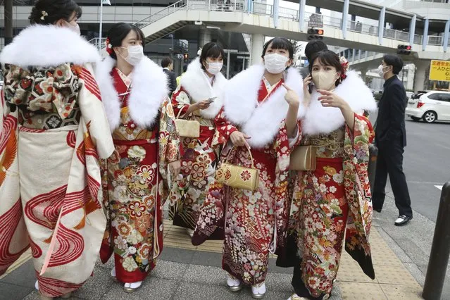 Women clad in Japan's traditional kimono outfits, who have just turned or will be 20 years old this year, walk on the street as they celebrate Coming of Age Day in Yokohama Monday, January 10, 2022. (Photo by Koji Sasahara/AP Photo)