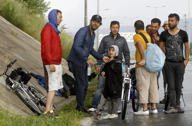 A group of migrants from Syria and Iraq rest to shelter from the rain in an underpass near Petrovec, some 20 kms (12 miles) east of Skopje, Macedonia, Wednesday, June 17, 2015. Macedonia has become one of the main transit routes for thousands of migrants from the Middle East and Africa who enter the European Union in Greece from Turkey and then make their way overland on foot or bicycle to the more prosperous northern countries. (AP Photo/Boris Grdanoski)