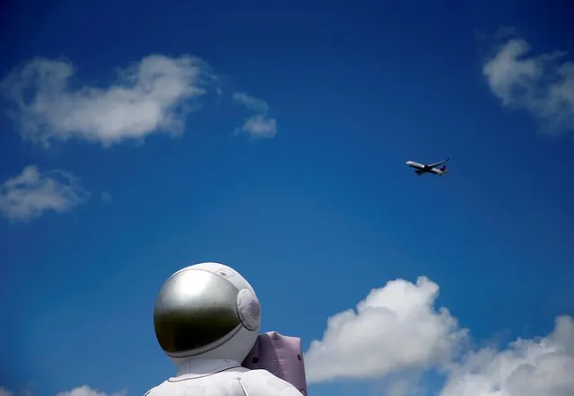 A plane passes by a large inflated astronaut outside the Museum of Flight on the anniversary of the Apollo 11 mission launch in Seattle, Washington, U.S., July 16, 2019. (Photo by Lindsey Wasson/Reuters)