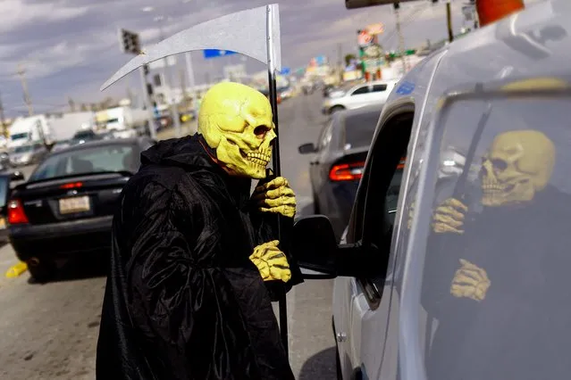 A Civil Protection employee dressed as death participates in the campaign “Beware of Monoxide, the Silent Killer”, which seeks to prevent deaths from poisoning with carbon monoxide through the use of heaters to mitigate low temperatures, on an avenue in Ciudad Juarez, Mexico on February 2, 2022. (Photo by Jose Luis Gonzalez/Reuters)